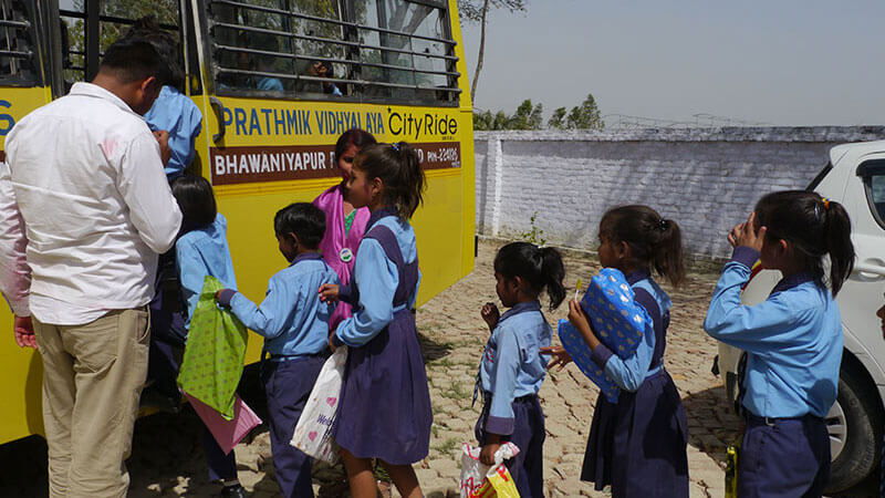 zeigt Mädchen beim einsteigen in einen Schulbus in Faizabad Indien