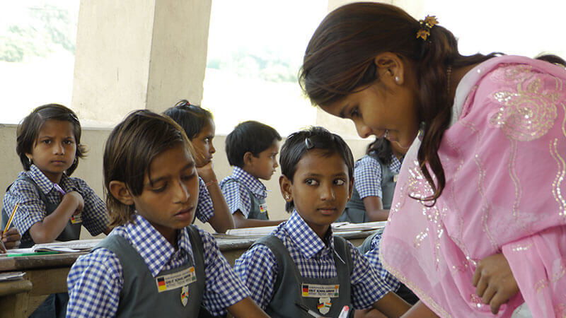 Mädchen in Indien in der Schule, die von einer Indischen Lehrerin Unterrichtet werden